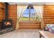 Bedroom featuring a cozy fireplace and large window with expansive views at 6150 Bluebell Ln, Evergreen, CO 80439