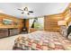 Log walled bedroom boasting a wood burning fireplace, ceiling fan, and serene outdoor views at 6150 Bluebell Ln, Evergreen, CO 80439
