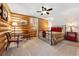 Spacious bedroom with log walls, carpet floors, ceiling fan, and a quaint sitting area at 6150 Bluebell Ln, Evergreen, CO 80439