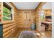 Warm entryway featuring log walls, hardwood floors, and a wooden door welcomes you home at 6150 Bluebell Ln, Evergreen, CO 80439