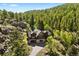 Charming home nestled in a lush forest, featuring stone accents and a private driveway at 6150 Bluebell Ln, Evergreen, CO 80439