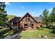 Beautiful log home with a large deck and well-maintained landscaping, perfect for enjoying the outdoors at 6150 Bluebell Ln, Evergreen, CO 80439