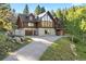 Stunning log home features a stone foundation, attached garage, and natural landscaping at 6150 Bluebell Ln, Evergreen, CO 80439