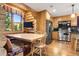 Rustic kitchen featuring log walls, stainless steel appliances, and a cozy dining nook with scenic views at 6150 Bluebell Ln, Evergreen, CO 80439