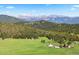 Scenic landscape view features rolling hills, lush forests, and snow-capped mountains in the background at 6150 Bluebell Ln, Evergreen, CO 80439
