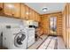 Laundry room with wood cabinetry, stacked washer/dryer and access to the outdoors at 6150 Bluebell Ln, Evergreen, CO 80439