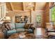 Open-concept living room with vaulted ceilings, log accents, and seamless access to outdoor spaces at 6150 Bluebell Ln, Evergreen, CO 80439