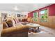 Spacious living room with wood paneled walls, large windows, and comfortable seating at 6150 Bluebell Ln, Evergreen, CO 80439