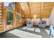 Bright living room with a wooden ceiling, large windows, and comfortable seating area at 6150 Bluebell Ln, Evergreen, CO 80439