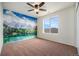 A carpeted bedroom features a scenic mountain view mural and a window that provides natural light at 1788 Taos St, Brighton, CO 80603
