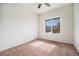 A bright bedroom offers natural light through a window, complemented by plush carpet flooring at 1788 Taos St, Brighton, CO 80603