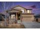 Charming two-story home featuring stone accents, neutral color palette, and an attached two-car garage, enhanced by a beautiful sunset at 1788 Taos St, Brighton, CO 80603
