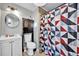 Neat bathroom with patterned shower curtain, mirrored cabinet, and white fixtures at 1841 Ruth Dr, Thornton, CO 80229