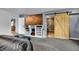 A spacious bedroom with a view to an ensuite and a large entertainment center at 1841 Ruth Dr, Thornton, CO 80229