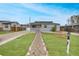 Charming single-story home with a well-manicured lawn and welcoming stone pathway at 1841 Ruth Dr, Thornton, CO 80229