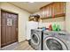 Well-equipped laundry room with modern washer and dryer units, cabinets, and convenient exterior access at 1841 Ruth Dr, Thornton, CO 80229