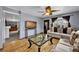 Open living space with wood floors, large windows, and a view to the entryway and dining area at 1841 Ruth Dr, Thornton, CO 80229