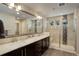 Bathroom with double vanity, large mirror, and tiled shower with built in seat at 2305 Prospect Ln, Broomfield, CO 80023