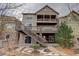 Rear exterior view featuring multiple balconies, stone accents, and a wooden staircase at 2305 Prospect Ln, Broomfield, CO 80023