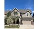 Charming two-story home featuring a two-car garage, stone accents, and blossoming tree in the front yard at 2305 Prospect Ln, Broomfield, CO 80023