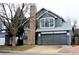 Charming two-story home features gray siding, brick chimney, and a two-car garage at 4243 Flanders St, Denver, CO 80249