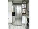 Stainless steel refrigerator complemented by granite countertops and white cabinets in this well-lit kitchen at 4243 Flanders St, Denver, CO 80249