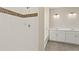 Modern bathroom featuring white tiled shower with decorative trim and double vanity sinks at 1850 Sawtooth Mountain Dr, Berthoud, CO 80513