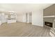 Open-concept living room with wood floors, a modern fireplace, and seamlessly connected kitchen area at 1850 Sawtooth Mountain Dr, Berthoud, CO 80513