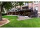 Expansive backyard featuring a lush green lawn, a patio and a multilevel deck at 8047 S Fairfax Ct, Centennial, CO 80122