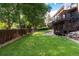 Well-manicured backyard with lush lawn, wood fence and multilevel deck at 8047 S Fairfax Ct, Centennial, CO 80122