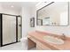 Charming bathroom with pink tile counters, black framed shower, and modern fixtures at 8047 S Fairfax Ct, Centennial, CO 80122