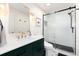 Stylish bathroom with black shower frame, green vanity, and hexagon tile accents at 8047 S Fairfax Ct, Centennial, CO 80122