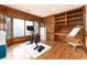 Well-lit exercise room with wood paneling, an exercise bike, a bay window, and built-in shelving at 8047 S Fairfax Ct, Centennial, CO 80122