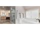 Luxurious bathroom features a soaking tub, a glass-enclosed shower, dual sinks, and herringbone-patterned tile accents at 8047 S Fairfax Ct, Centennial, CO 80122