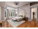 Inviting bedroom featuring a four-poster bed, hardwood floors, and sun-filled windows at 8047 S Fairfax Ct, Centennial, CO 80122