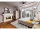 Inviting bedroom featuring a fireplace, four-poster bed, hardwood floors, and sun-filled windows at 8047 S Fairfax Ct, Centennial, CO 80122