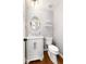 Neat powder room with a round mirror, white vanity, marble countertop, and classic fixtures at 8047 S Fairfax Ct, Centennial, CO 80122