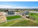 An aerial view reveals a beautifully landscaped property with a large yard, white fencing, and additional building with playground at 16360 Paris Way, Brighton, CO 80602