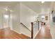 Bright hallway features wood floors, stairs, and an open view to the sitting area and bathroom at 16360 Paris Way, Brighton, CO 80602