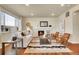 Cozy living room featuring a fireplace, hardwood floors, large windows, and comfortable seating at 16360 Paris Way, Brighton, CO 80602