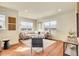 A modern living room showcases recessed lighting, lots of light and seating, and stylish decor at 16360 Paris Way, Brighton, CO 80602