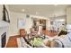 Open concept living room showcases hardwood floors, a fireplace, and seamless integration with the dining area at 16360 Paris Way, Brighton, CO 80602