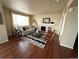 Bright living room boasts a fireplace, neutral decor, and hardwood floors at 16360 Paris Way, Brighton, CO 80602