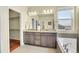 The main bathroom offers double sinks, a large mirror, and a separate toilet room with walk-in closet at 16360 Paris Way, Brighton, CO 80602