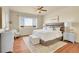 A bright main bedroom is showcased, featuring a ceiling fan and a large window with scenic views at 16360 Paris Way, Brighton, CO 80602
