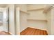 This walk-in closet features built-in shelving, wood flooring, and a door for convenience at 16360 Paris Way, Brighton, CO 80602