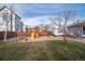 Fenced backyard featuring playground with slide, swing set, and parking area at 1571 Sheridan Blvd, Lakewood, CO 80214