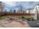 Spacious backyard with stone patio, fire pit, grill, and table seating, perfect for outdoor entertaining at 1571 Sheridan Blvd, Lakewood, CO 80214