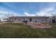 A well-maintained backyard features a patio with a fire pit, seating, and a grill ideal for outdoor entertaining at 1571 Sheridan Blvd, Lakewood, CO 80214