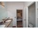Bathroom with double sink vanity leading to an adjoining bedroom and water closet at 1571 Sheridan Blvd, Lakewood, CO 80214